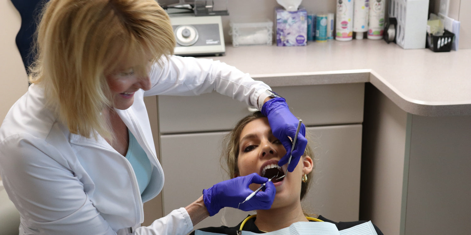 General dentist, DDS, working inside a patient's mouth performing an examination.